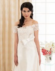 Langes Brautkleid mit Carmen Ausschnitt aus Seide und Spitze mit großer Schleife vorne